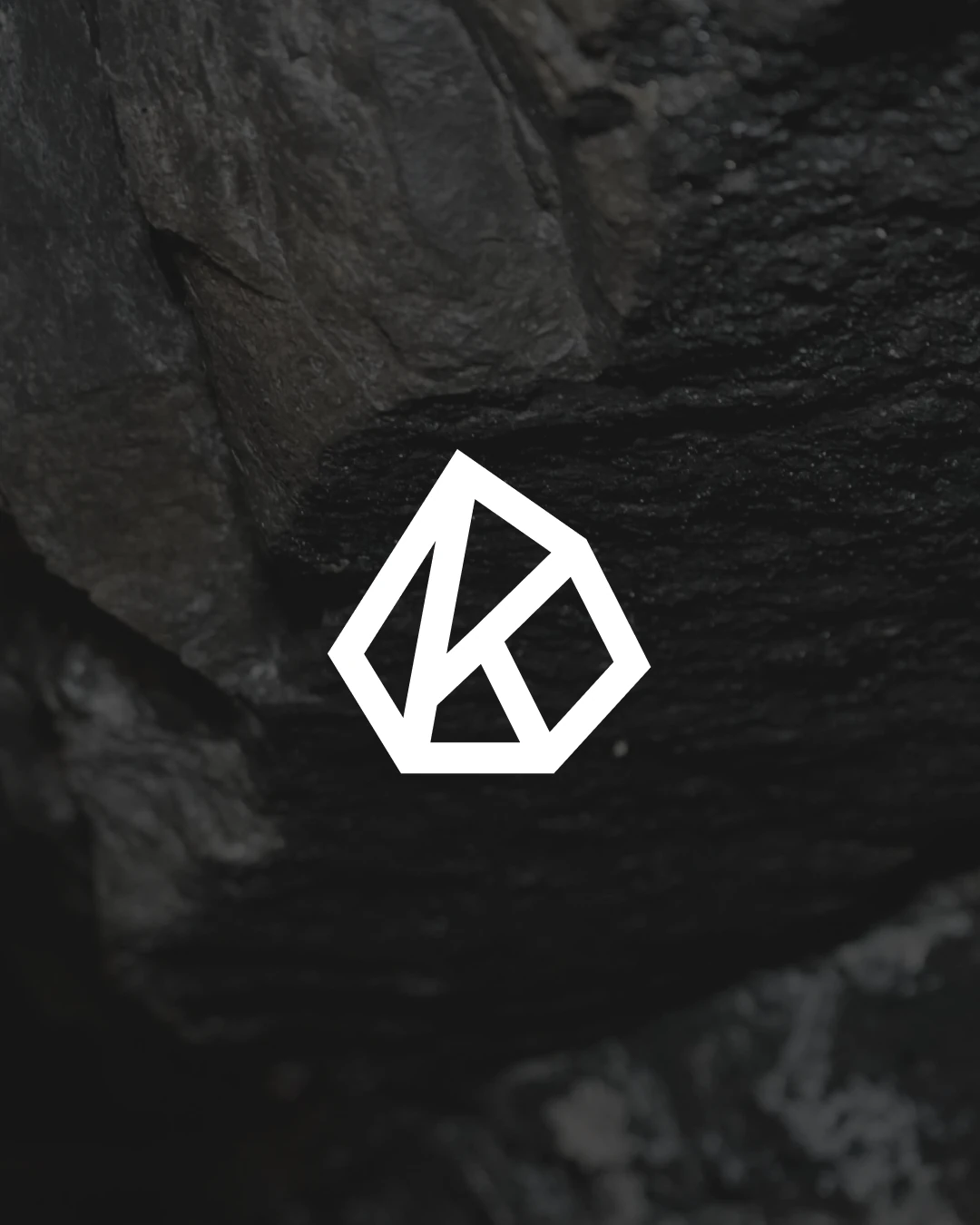 Kedalion K monogram over dark rock